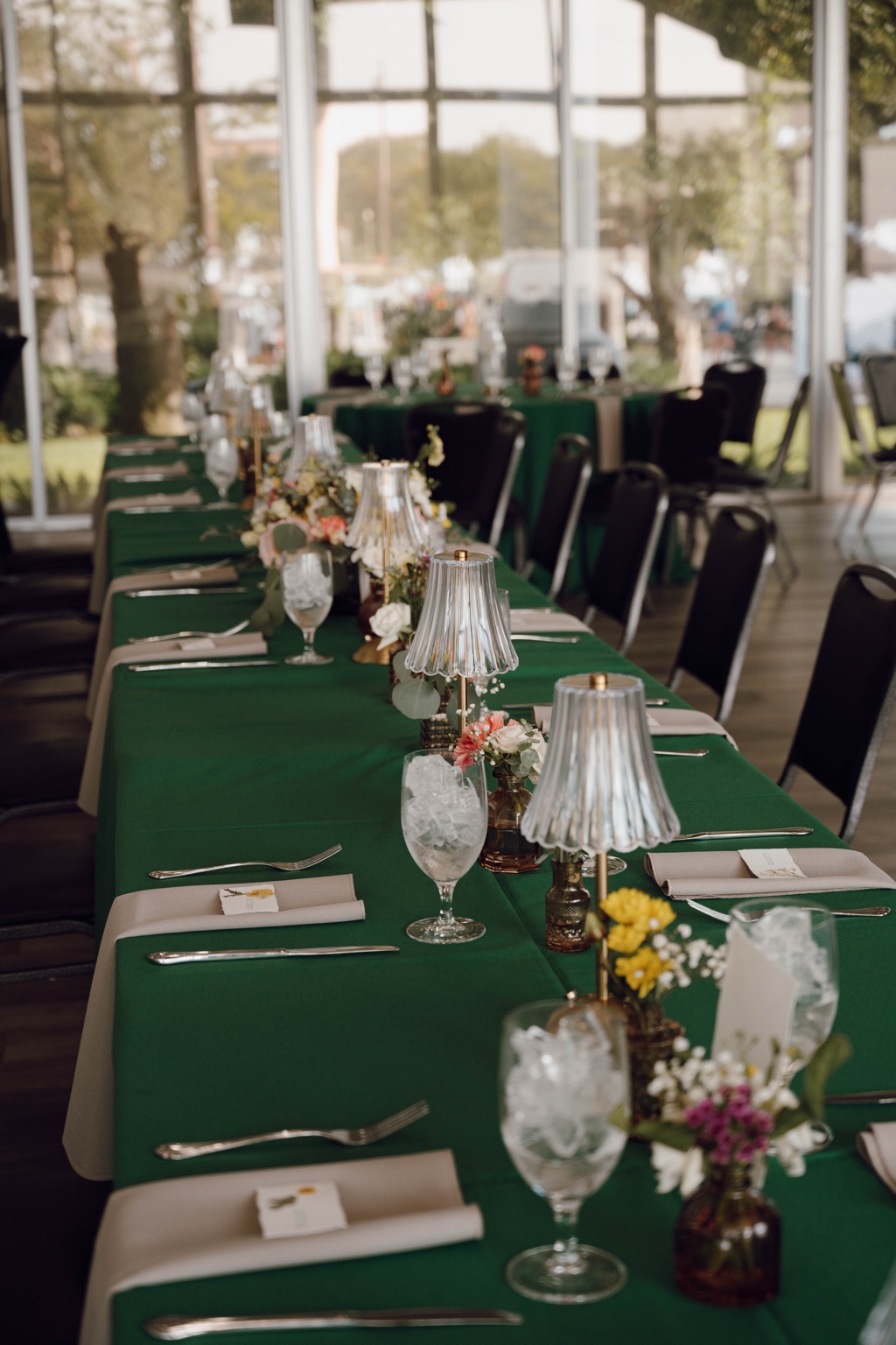Reception tables dressed in soft green linens and intimate florals