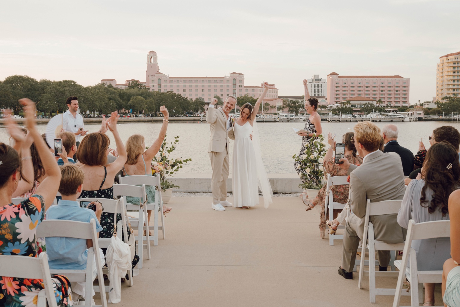Newlyweds celebrating with their guests beside the water