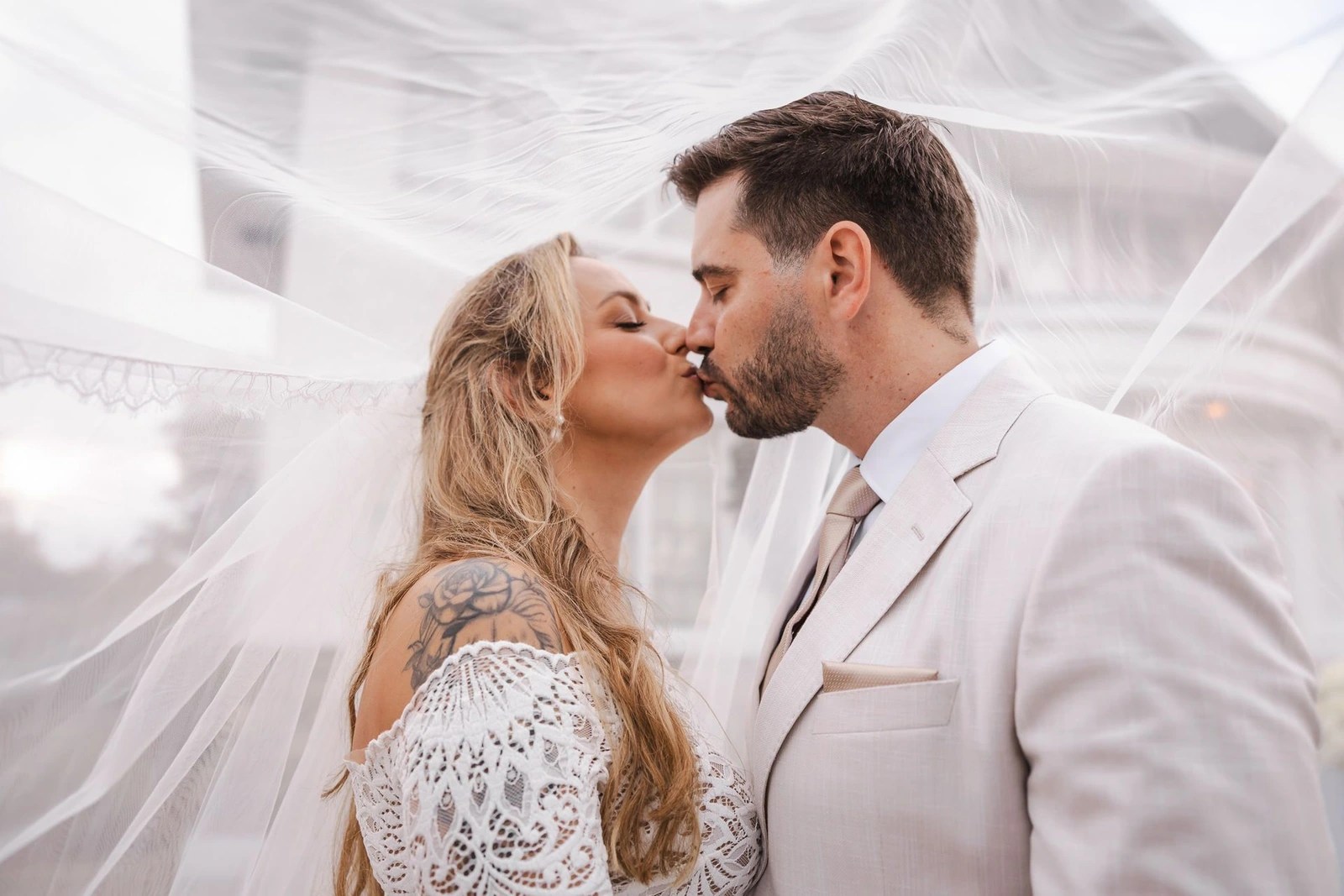 Newlyweds sharing a quiet kiss beneath the bride's veil